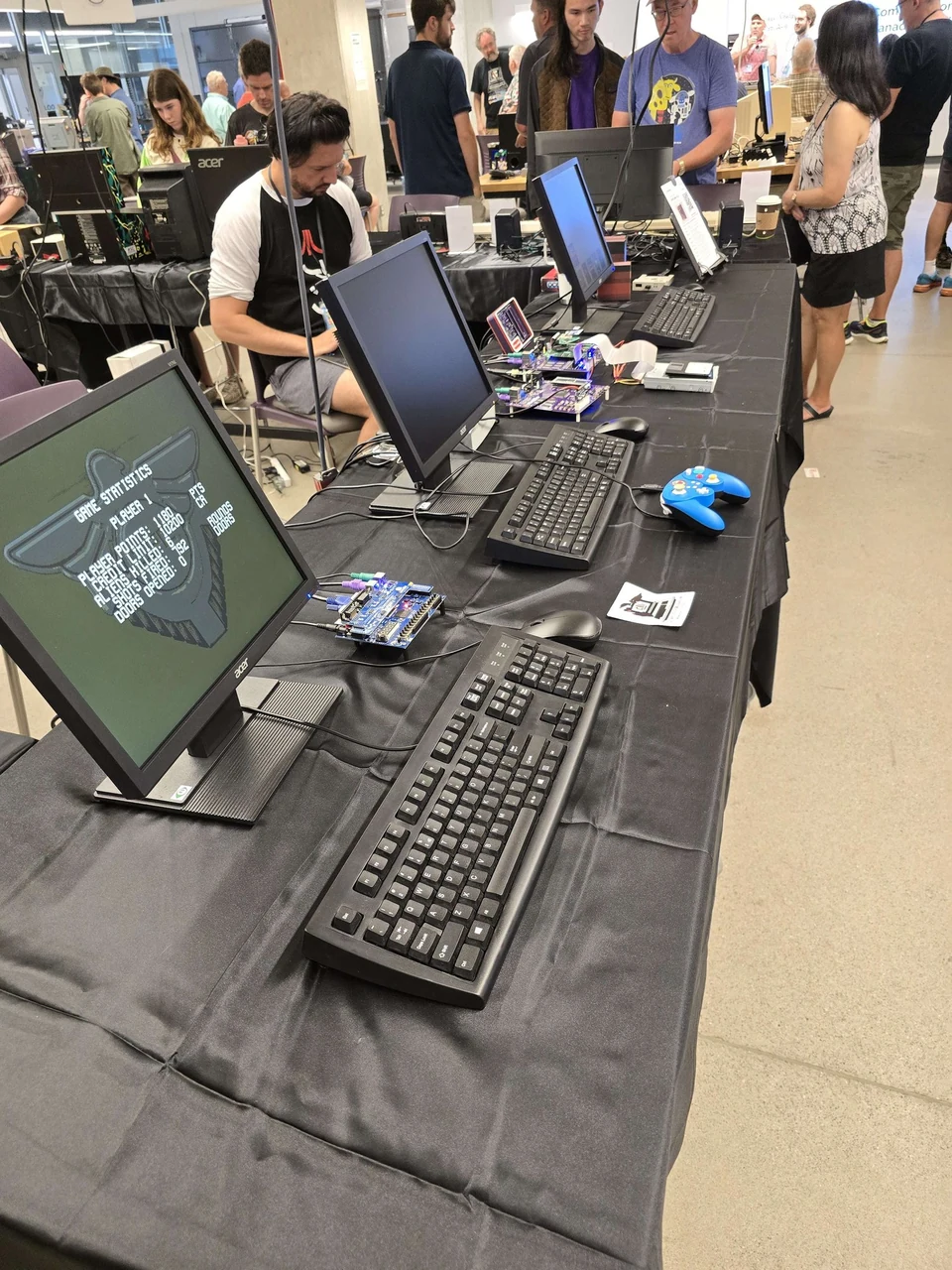 Visitors gathered beside running computers and exposed Minimig hardware at WoRC Expo 2026